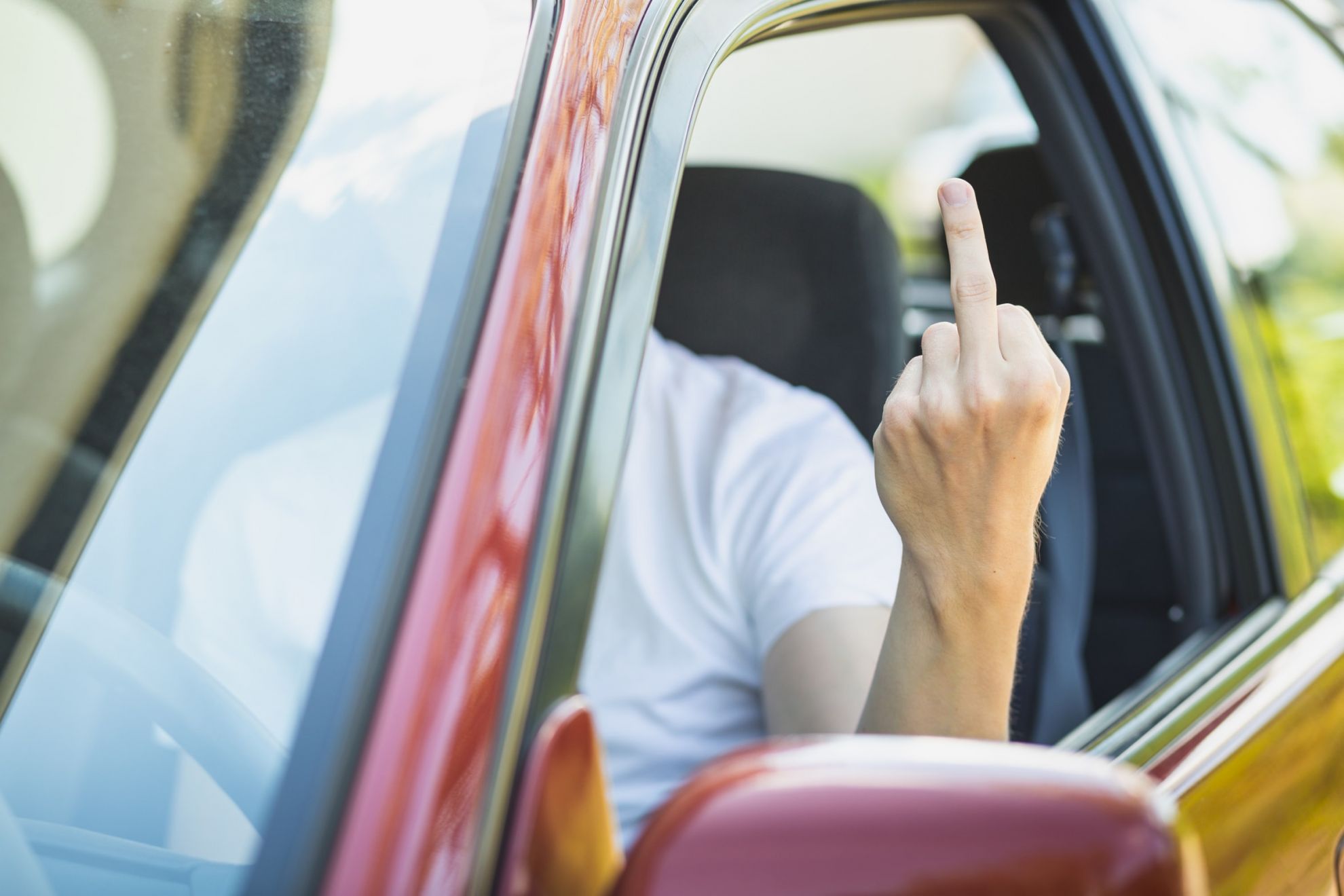 Ein Autofahrer zeigt den Mittelfinger.
