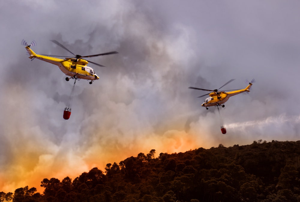 Hubschrauber transportieren Löschwasser. (Foto: AdobeStock/lassedesignen)