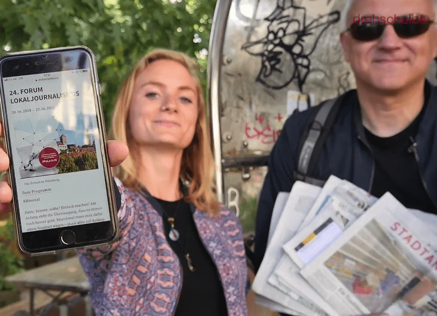 Katharina Dodel und Stefan Wirner mit einem Handy, das Infos zum Forum zeigt.